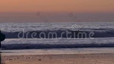 冲浪者在圣克莱门塔的橘红色日落与史诗般的光线和太阳耀斑木码头与木板行走